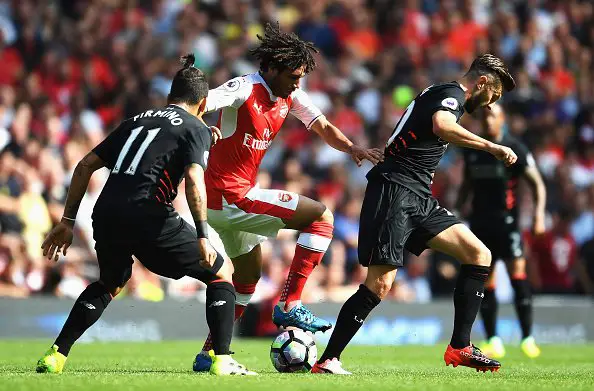 LONDON, ENGLAND - AUGUST 14: Mohamed Elneny of Arsenal takes on Roberto Firmino and Adam Lallana of Liverpool during the Premier League match between Arsenal and Liverpool at Emirates Stadium on August 14, 2016 in London, England.  (Photo by Mike Hewitt/Getty Images)