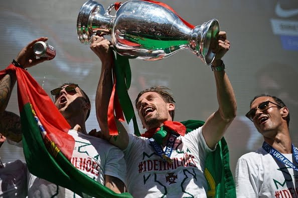 Portugal's midfielder Adrien Silva (C) holds the trophy accompanied by Portugal's defender Vieirinha (L) and Portugal's defender Rui de Carvalho at Alameda square in Lisbon on July 11, 2016 where thousands of supporters welcome them with scarfs and flags to celebrate their victory over France in their Euro 2016 final football yesterday.
The Portuguese football team returned home to a heroes' welcome today after their upset 1-0 win triumph over France in the Euro 2016 final.

 / AFP / PATRICIA DE MELO MOREIRA        (Photo credit should read PATRICIA DE MELO MOREIRA/AFP/Getty Images)