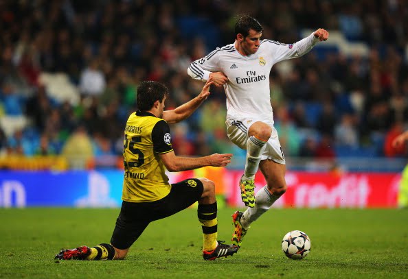 MADRID, SPAIN - APRIL 02:  Gareth Bale of Real Madrid takes on Sokratis Papastathopoulos of Borussia Dortmund during the UEFA Champions League Quarter Final first leg match between Real Madrid and Borussia Dortmund at Estadio Santiago Bernabeu on April 2, 2014 in Madrid, Spain.  (Photo by Clive Rose/Getty Images)