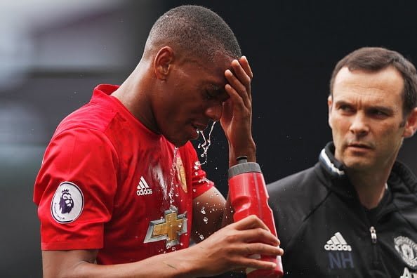 Manchester United's French striker Anthony Martial pours water on his face after being hurt in a challenge during the English Premier League football match between Watford and Manchester United at Vicarage Road Stadium in Watford, north of London on September 18, 2016. / AFP / Adrian DENNIS / RESTRICTED TO EDITORIAL USE. No use with unauthorized audio, video, data, fixture lists, club/league logos or 'live' services. Online in-match use limited to 75 images, no video emulation. No use in betting, games or single club/league/player publications.  /         (Photo credit should read ADRIAN DENNIS/AFP/Getty Images)