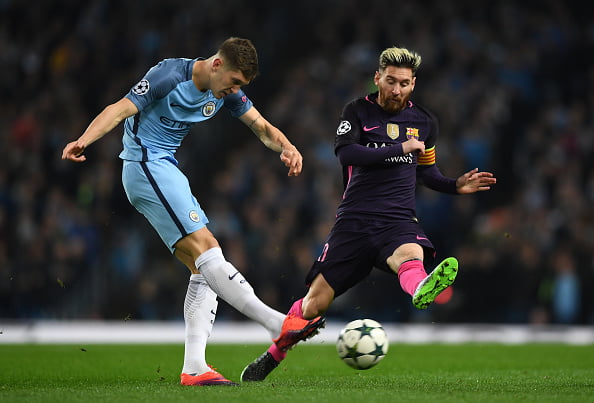 MANCHESTER, ENGLAND - NOVEMBER 01:  John Stones of Manchester City (L) shoots while Lionel Messi of Barcelona (R) attempts to block during the UEFA Champions League Group C match between Manchester City FC and FC Barcelona at Etihad Stadium on November 1, 2016 in Manchester, England.  (Photo by Shaun Botterill/Getty Images)