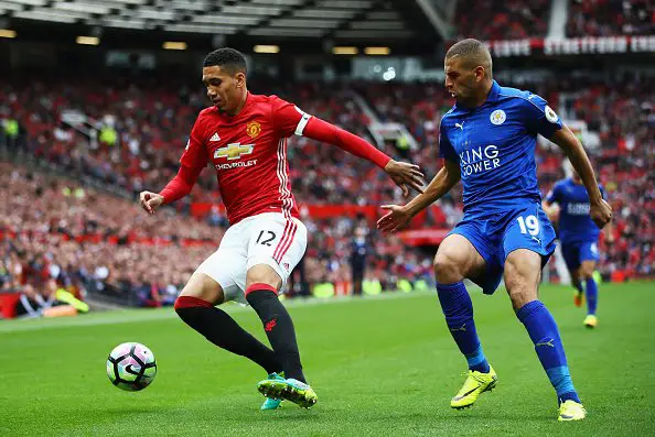 MANCHESTER, ENGLAND - SEPTEMBER 24: Chris Smalling of Manchester United (L) attempts to keep the ball while under pressure from Islam Slimani of Leicester City (R)  during the Premier League match between Manchester United and Leicester City at Old Trafford on September 24, 2016 in Manchester, England.  (Photo by Clive Brunskill/Getty Images)