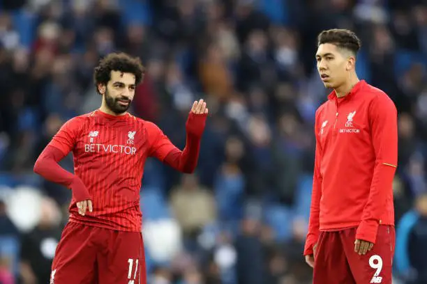 Mohamed Salah of Liverpool and Roberto Firmino of Liverpool speak during their warm up prior to the Premier League match between Brighton & Hove Albion and Liverpool FC at American Express Community Stadium on January 12, 2019 in Brighton, United Kingdom. (Photo by Bryn Lennon/Getty Images)