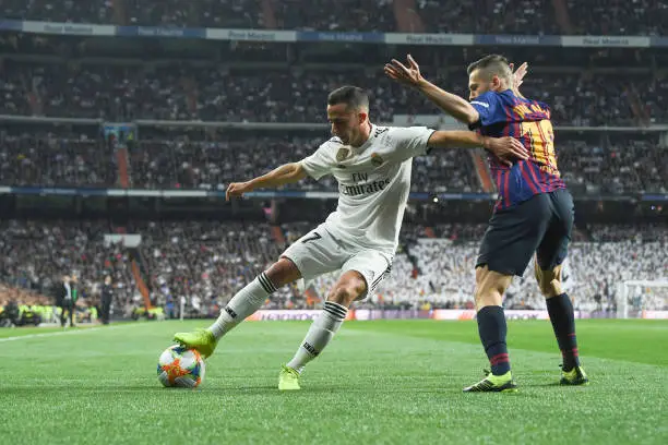 MADRID, SPAIN - FEBRUARY 27: Lucas Vazquez (L) of Real Madrid is challenged by Jordi Alba of FC Barcelona during the Copa del Rey Semi Final second leg match between Real Madrid and FC Barcelona at Bernabeu on February 27, 2019 in Madrid, Spain. (Photo by David Ramos/Getty Images)