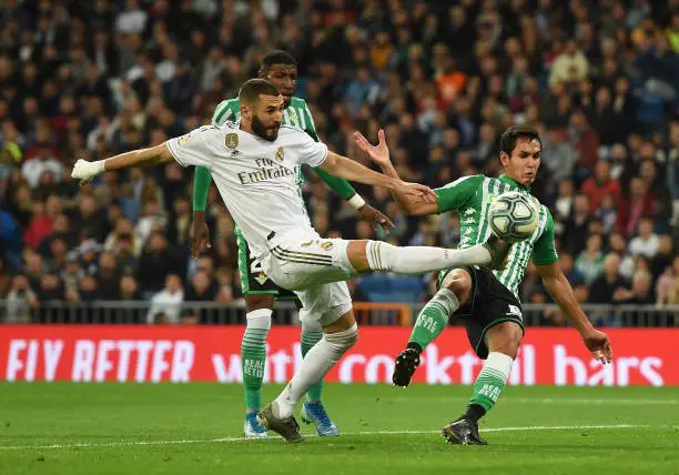 MADRID, SPAIN - NOVEMBER 02: Karim Benzema of Real Madrid CF connects with a cross beside Mandi of Real Betis Balompie during the Liga match between Real Madrid CF and Real Betis Balompie at Estadio Santiago Bernabeu on November 02, 2019 in Madrid, Spain. (Photo by Denis Doyle/Getty Images)