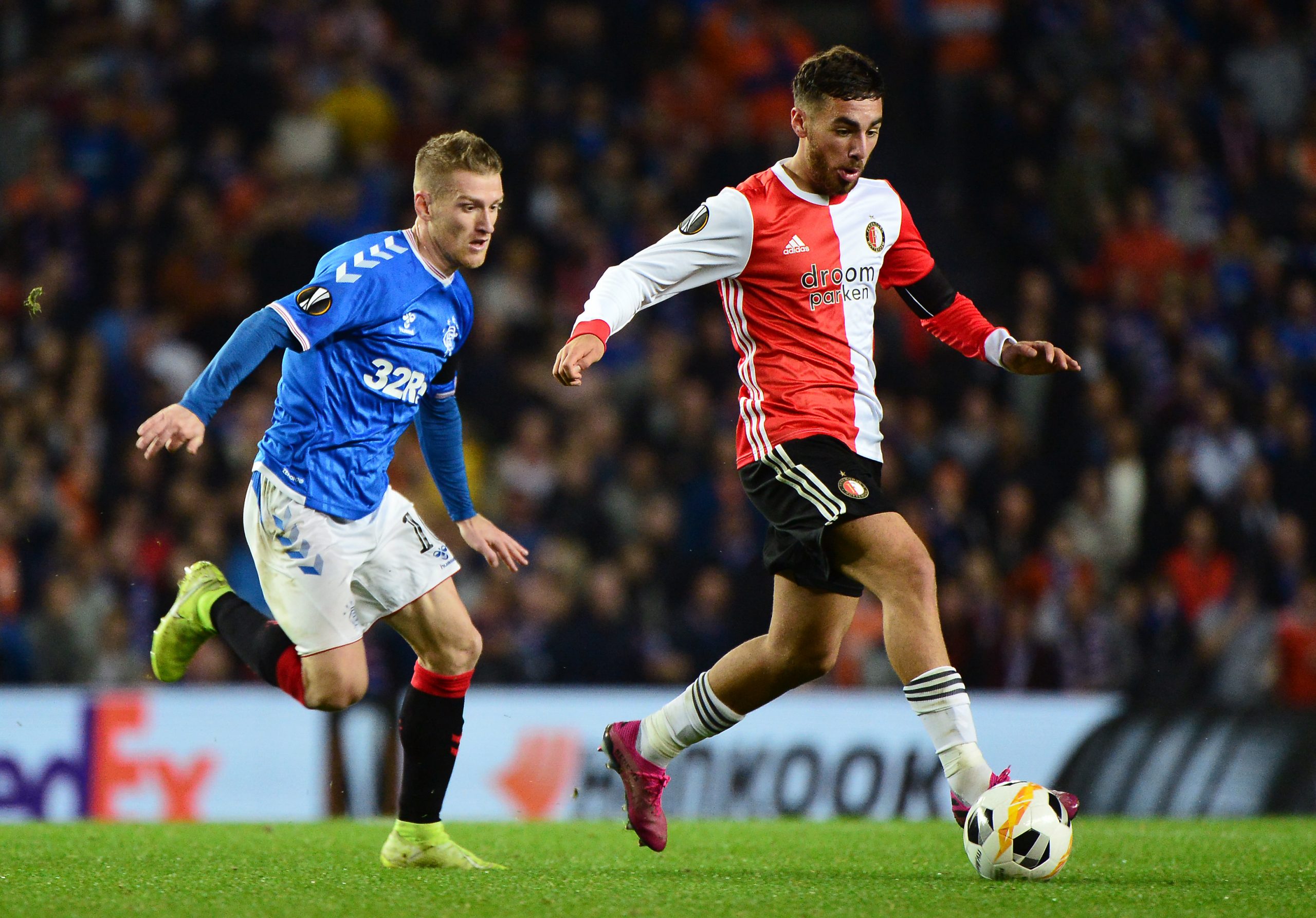 Orkun Kokcu of Feyenoord runs past Steven Davis of Rangers FC during the UEFA Europa League group G match between Rangers FC and Feyenoord at Ibrox Stadium on September 19, 2019 in Glasgow, United Kingdom. (Photo by Mark Runnacles/Getty Images)