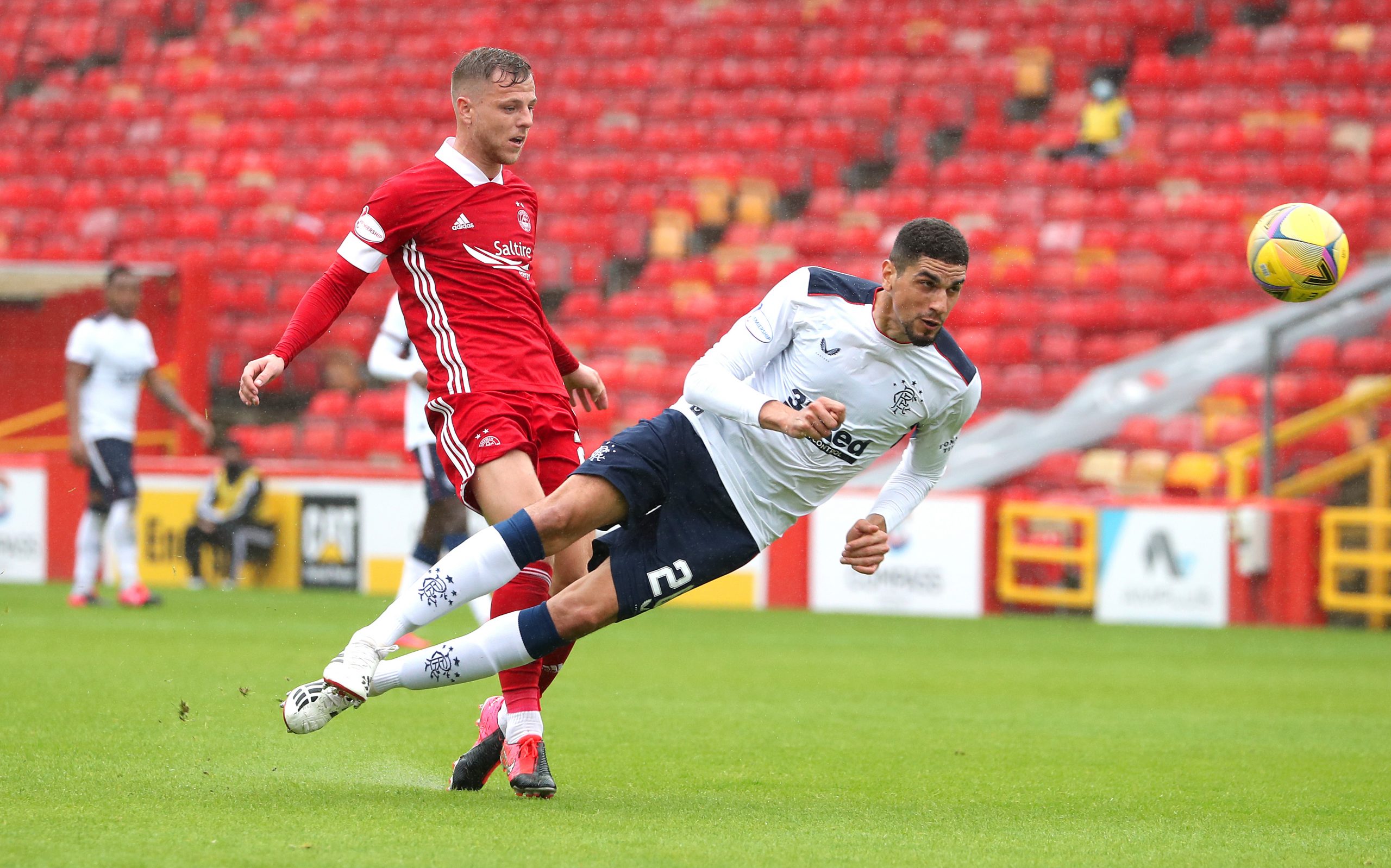 ABERDEEN, SCOTLAND - AUGUST 01: Bruce Anderson of Aberdeen is challenged by Leon Balogun of Rangers FC during the Ladbrokes Premiership match between Aberdeen and Rangers at Pittodrie Stadium on August 01, 2020 in Aberdeen, Scotland. (Photo by Andrew Milligan/Pool via Getty Images)