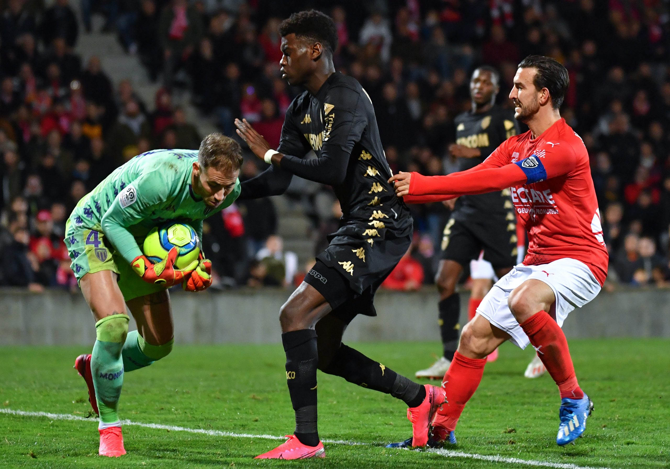 Monaco's French goalkeeper Benjamin Lecomte (L) stops  the ball in front of Monaco's French midfiedler Benoît Badiashile (C) and Nimes' French defender Pablo Martinez (R)  during the French L1 football match between Nimes (NO) and Monaco (ASM) on February 1, 2020, at the Costieres Stadium in Nimes, southern France. (Photo by PASCAL GUYOT/AFP via Getty Images)