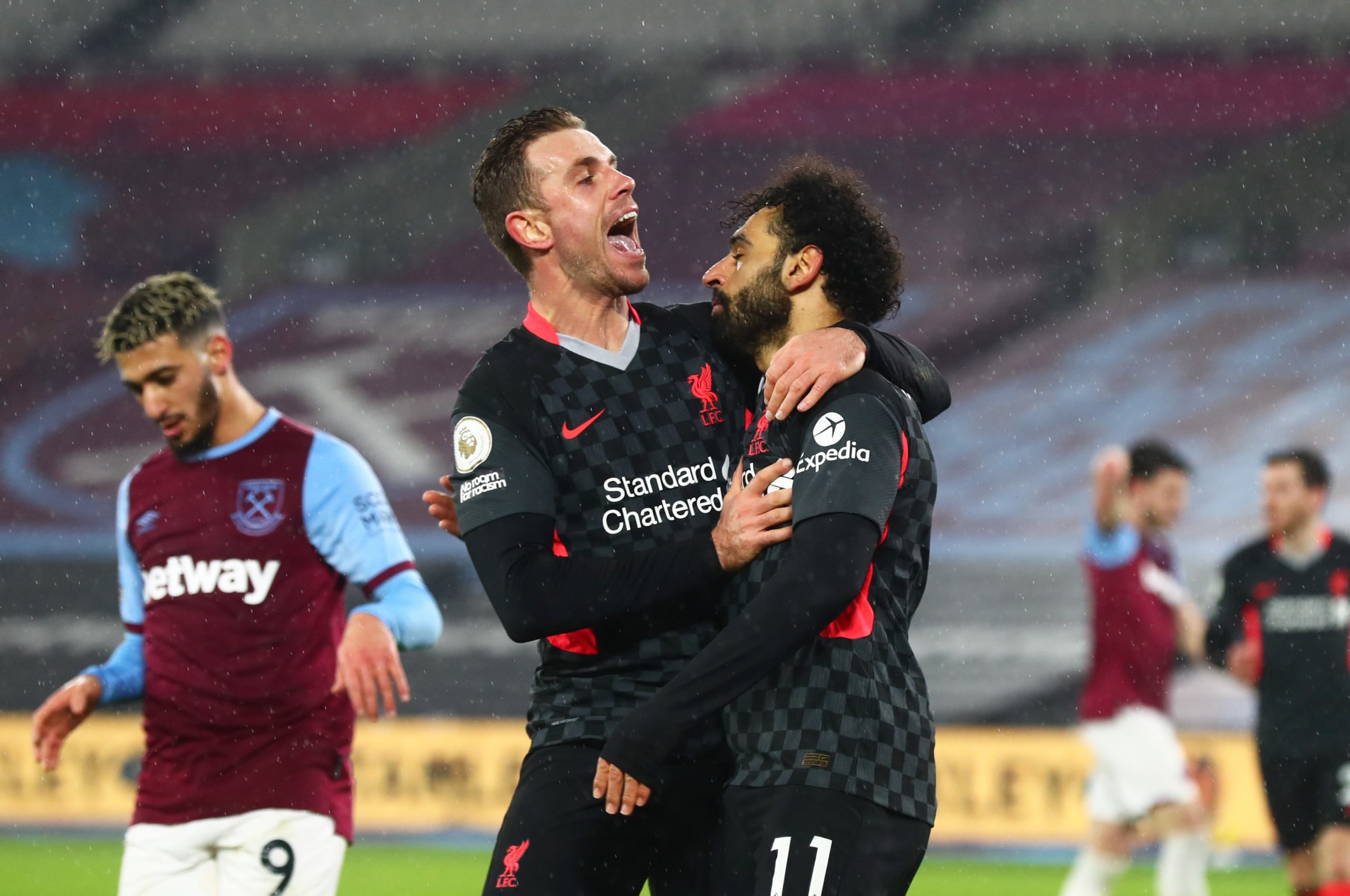 Mohamed Salah of Liverpool celebrates with teammate Jordan Henderson after scoring their side's second goal during the Premier League match between West Ham United and Liverpool at London Stadium on January 31, 2021 in London, England. Sporting stadiums around the UK remain under strict restrictions due to the Coronavirus Pandemic as Government social distancing laws prohibit fans inside venues resulting in games being played behind closed doors. (Photo by Clive Rose/Getty Images)