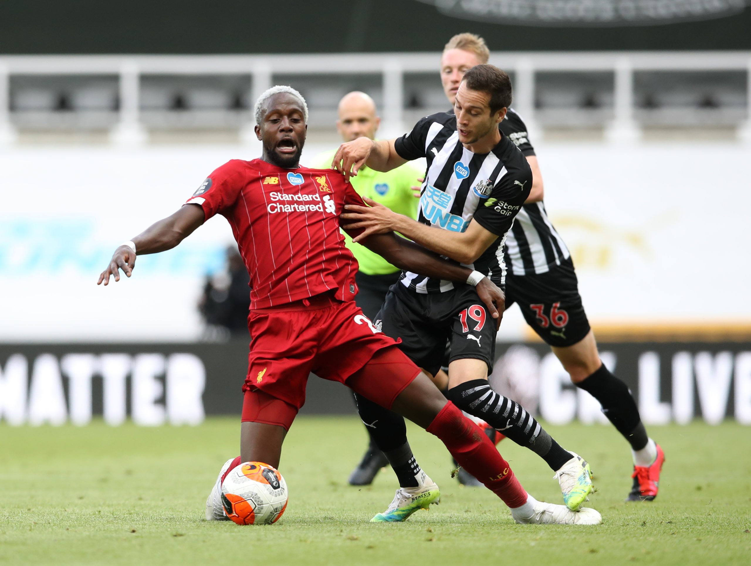 NEWCASTLE UPON TYNE, ENGLAND - JULY 26: Divock Origi of Liverpool  battles for possession with Javier Manquillo of Newcastle United  during the Premier League match between Newcastle United and Liverpool FC at St. James Park on July 26, 2020 in Newcastle upon Tyne, England. Football Stadiums around Europe remain empty due to the Coronavirus Pandemic as Government social distancing laws prohibit fans inside venues resulting in all fixtures being played behind closed doors. (Photo by Owen Humphreys/Pool via Getty Images)The 4th Official uses images provided by the following image agency: Getty Images (https://www.gettyimages.de/) Imago Images (https://www.imago-images.de/)