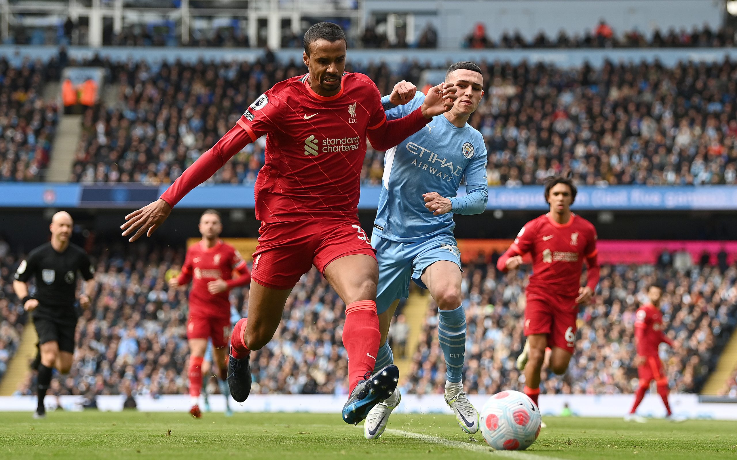 MANCHESTER, ENGLAND - APRIL 10: Joel Matip of Liverpool battles for possession with Phil Foden of Manchester City during the Premier League match between Manchester City and Liverpool at Etihad Stadium on April 10, 2022 in Manchester, England. (Photo by Shaun Botterill/Getty Images) The 4th Official uses images provided by the following image agency: Getty Images (https://www.gettyimages.de/) and Imago Images (https://www.imago-images.de/)