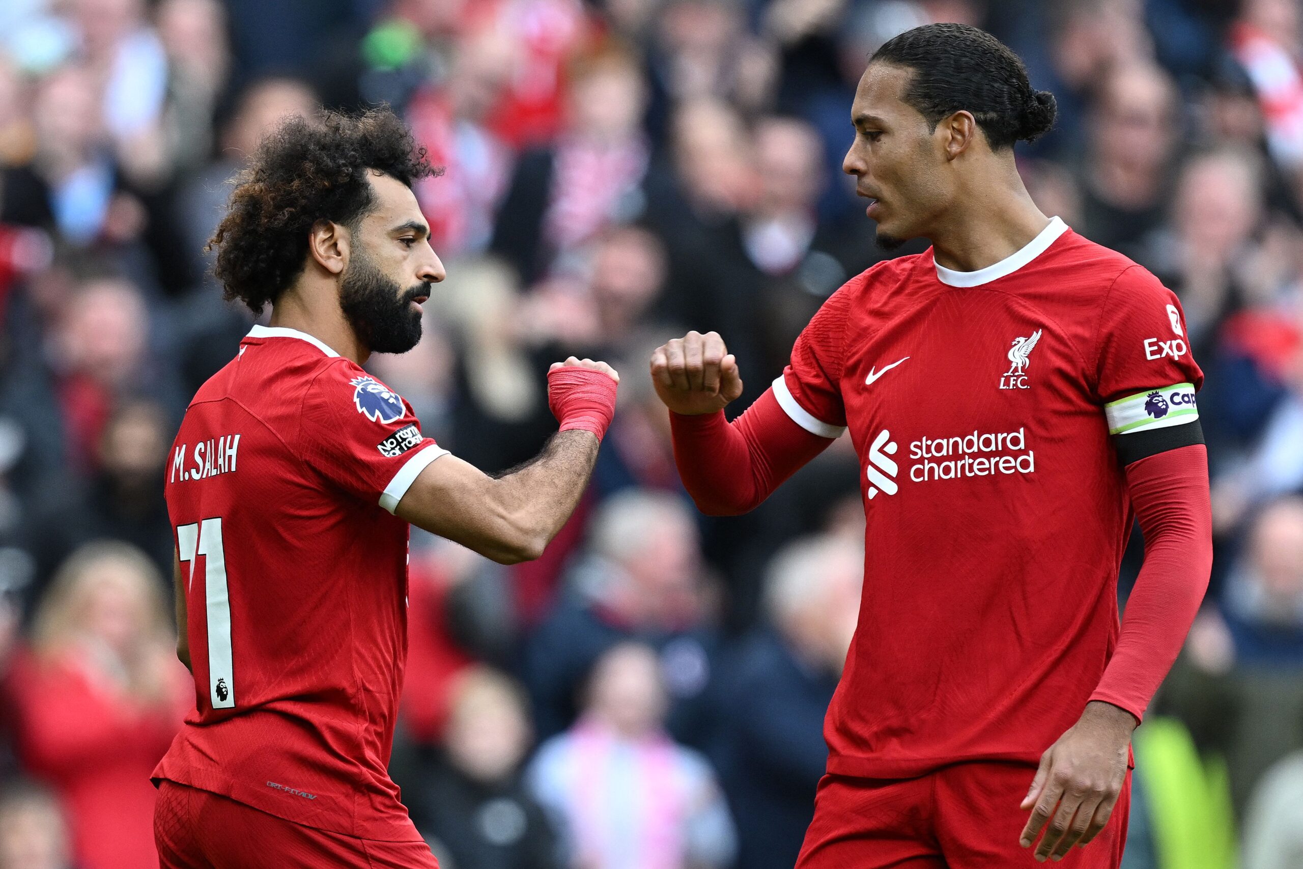 Liverpool's Egyptian striker #11 Mohamed Salah (L) celebrates scoring the opening goal from the penalty spot with Liverpool's Dutch defender #04 Virgil van Dijk during the English Premier League football match between Liverpool and Everton at Anfield in Liverpool, north west England on October 21, 2023. (Photo by Paul ELLIS / AFP) / RESTRICTED TO EDITORIAL USE. No use with unauthorized audio, video, data, fixture lists, club/league logos or 'live' services. Online in-match use limited to 120 images. An additional 40 images may be used in extra time. No video emulation. Social media in-match use limited to 120 images. An additional 40 images may be used in extra time. No use in betting publications, games or single club/league/player publications. /  (Photo by PAUL ELLIS/AFP via Getty Images)