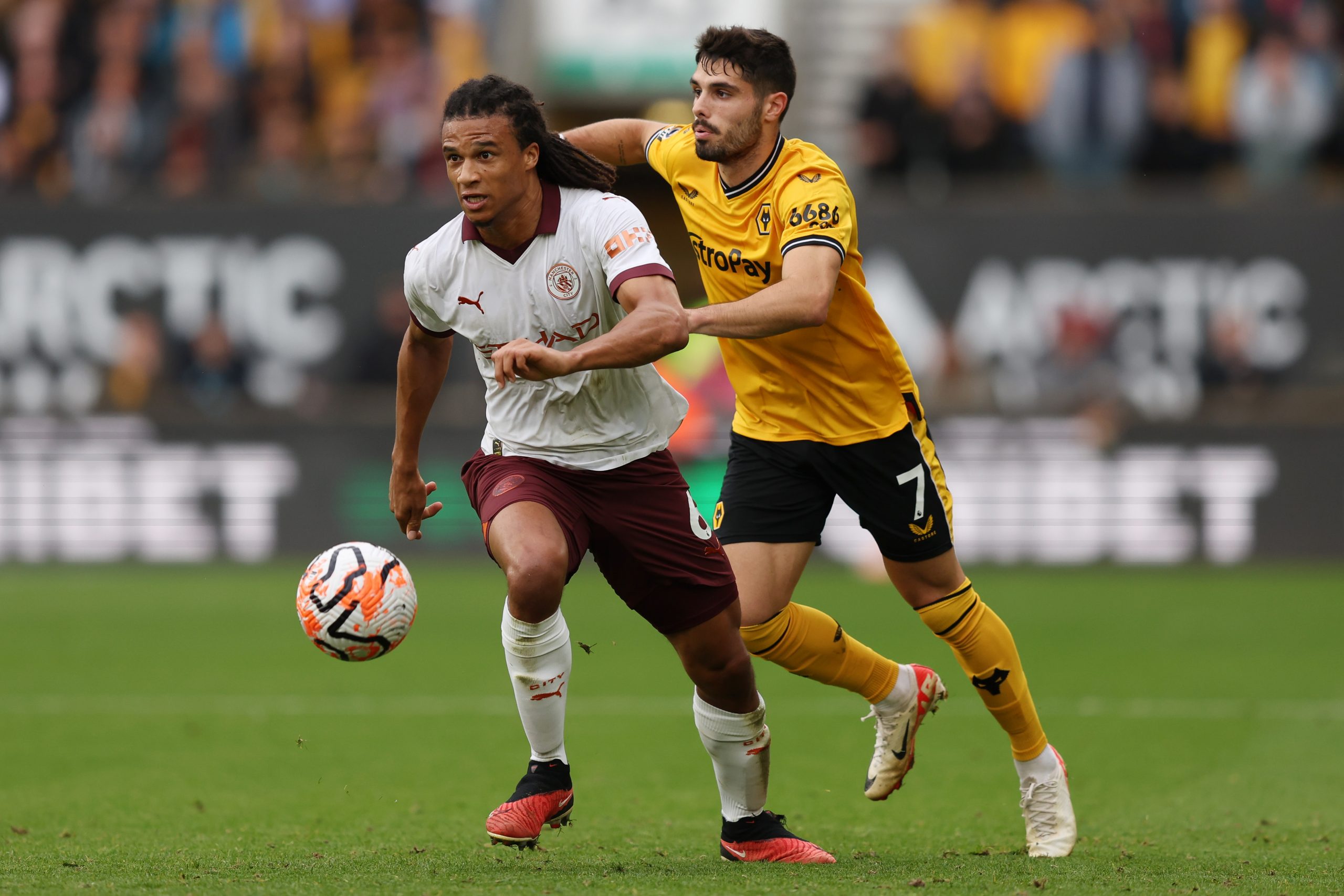 WOLVERHAMPTON, ENGLAND - SEPTEMBER 30: Nathan Ake of Manchester City battles for possession with Pedro Neto of Wolverhampton Wanderers during the Premier League match between Wolverhampton Wanderers and Manchester City at Molineux on September 30, 2023 in Wolverhampton, England. (Photo by Matt McNulty/Getty Images)