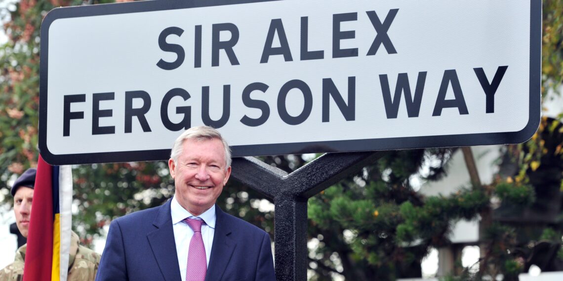 Former Manchester United manager Sir Alex Ferguson unveils a sign after a road near to Old Trafford Stadium was renamed in his honour in Manchester, north-west England, on October 14, 2013. AFP PHOTO / PAUL ELLIS        (Photo credit should read PAUL ELLIS/AFP via Getty Images)