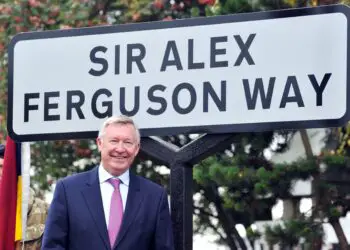 Former Manchester United manager Sir Alex Ferguson unveils a sign after a road near to Old Trafford Stadium was renamed in his honour in Manchester, north-west England, on October 14, 2013. AFP PHOTO / PAUL ELLIS        (Photo credit should read PAUL ELLIS/AFP via Getty Images)