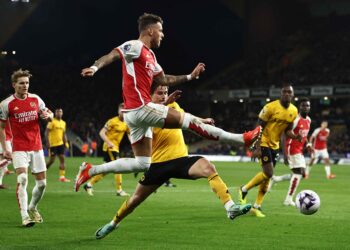 Arsenal's English defender #04 Ben White (C) crosses the ball during the English Premier League football match between Wolverhampton Wanderers and Arsenal at the Molineux stadium in Wolverhampton, central England on April 20, 2024. (Photo by HENRY NICHOLLS / AFP)