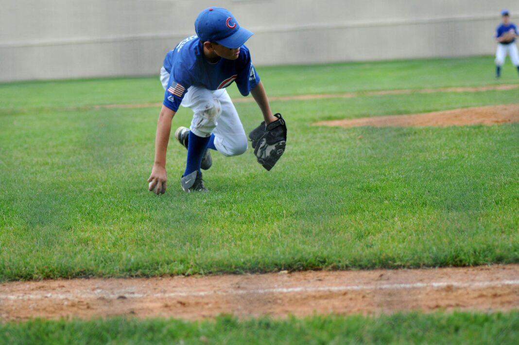 a young boy in Chicago Cubs jersey playing baseball