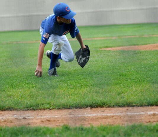 Why Sports Apparel Matters More Than We Think for Young Players a young boy in Chicago Cubs jersey playing baseball