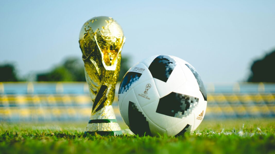 fauzan-saari-cjYQBSKDSII-unsplash The World Cup trophy on the ground with a football