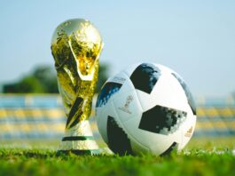 The World Cup trophy on the ground with a football