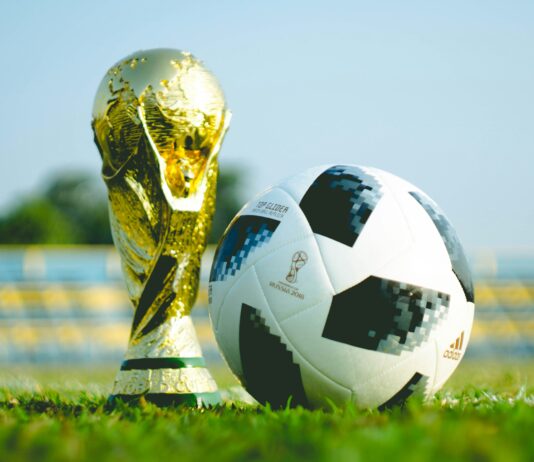 The World Cup trophy on the ground with a football